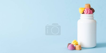 Téléchargez les photos : Concept de vitamines gommeuses - alternative de vitamines à croquer pour les enfants, fond bleu vif - en image libre de droit