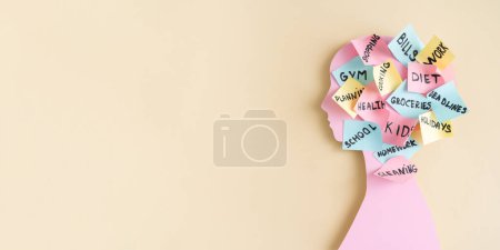 Foto de Concepto de carga mental - perfil rosa femenino, cabeza cubierta con notas post-it con diferentes aspectos de la vida, vista superior - Imagen libre de derechos