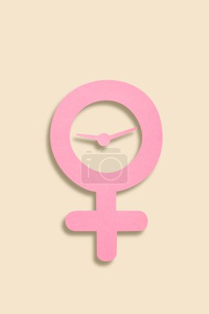 Foto de Concepto de menopausia - combinación de recorte de papel de símbolo femenino y reloj despertador, vista superior - Imagen libre de derechos