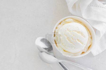 Foto de Vanilla ice cream in white cup, marble background Top view - Imagen libre de derechos