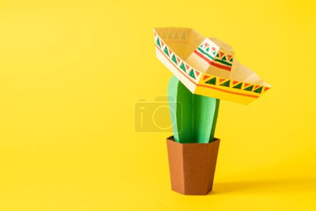 Cinco de Mayo concept - paper craft cactus in sombrero on solid color background. High quality photo