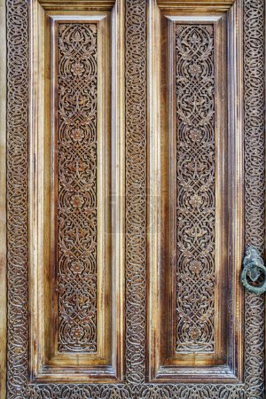 Carved antique wooden doors with patterns and mosaics.