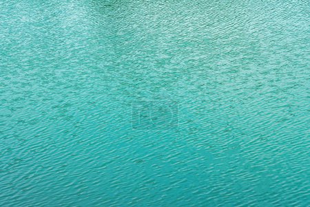 The texture of the waves of turquoise color of fast-flowing water in the river. Abstract nature background.