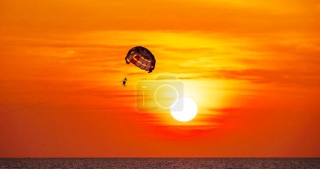 Photo for Silhouette Travel people Parasailing over sea Against sky during sunset in golden hour of sunset or sunrise sky,Active and extreme recreation - Royalty Free Image