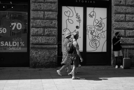 Foto de Pareja caminando frente a boutiques en el centro de milan - Imagen libre de derechos