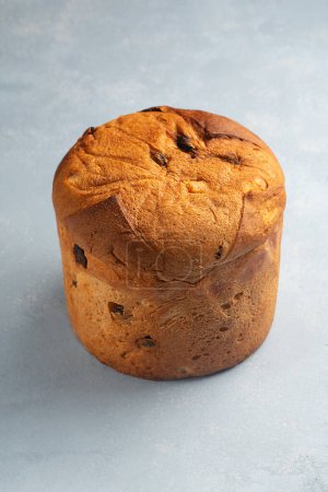  One panettone sweet bread , traditional Italian food for Christmas on a blue background, close up