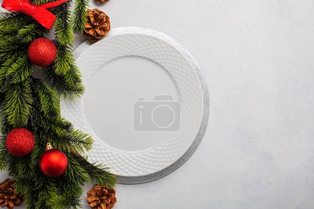 Foto de Ajuste de mesa de Navidad que consta de un plato blanco vacío y decoraciones. Vista superior, sobre fondo blanco con espacio para copiar - Imagen libre de derechos
