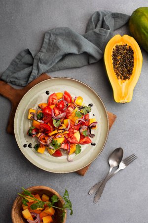 Téléchargez les photos : Papaya salad with tomatoes, red onion and balsamic vinegar. Top view - en image libre de droit