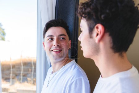 Foto de Pareja gay compartiendo un momento especial por la mañana junto a la ventana. Ternura romántica homosexual. Foto de alta calidad - Imagen libre de derechos