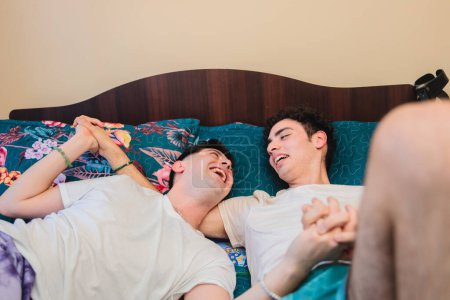 Photo for Close up shot of loving same sex male couple lying on bed at home hugging together. High quality photo - Royalty Free Image