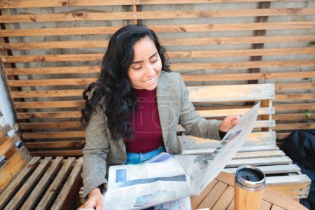 Téléchargez les photos : Chasse à l'emploi dans le style : Jeune femme latine à la recherche de possibilités d'emploi dans un café confortable. Photo de haute qualité - en image libre de droit