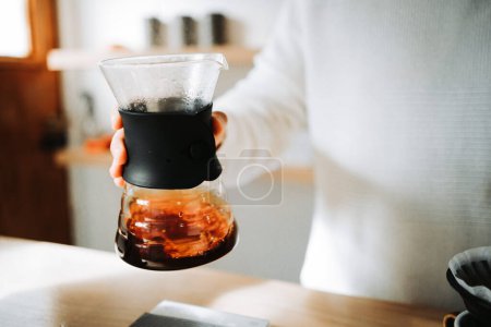 Téléchargez les photos : Rituel de café méticuleux : Mains magistrales engagées dans une méthode précise Chemex Verser-over dans un café local. Photo de haute qualité - en image libre de droit
