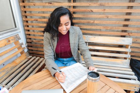 Photo for Job Hunting in Style: Young Latina Woman Searching for Employment Opportunities in a Cozy Cafe. High quality photo - Royalty Free Image