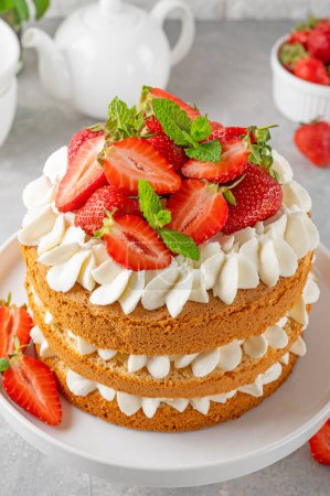 Téléchargez les photos : Gâteau aux fraises, gâteau à l'éponge vanille avec fromage à la crème et fraises fraîches. Du gâteau d'été. Concentration sélective - en image libre de droit