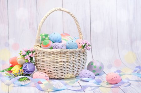 Photo for Wicker basket with painted Easter eggs on a light background, Easter composition, Easter card. High quality photo - Royalty Free Image