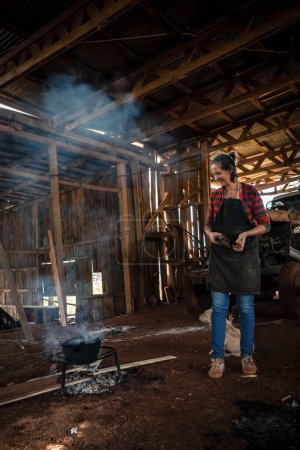 Foto de La joven de uniforme trabajando en una fábrica de cocina para todos con fuego en el suelo. - Imagen libre de derechos