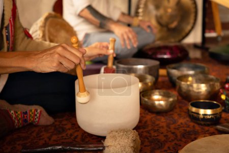 Photo for Close up of woman's hands playing quartz singing bowl. Relaxation and meditation. Sound therapy, alternative medicine. Clearing the space of negative energy. Selective focus. - Royalty Free Image