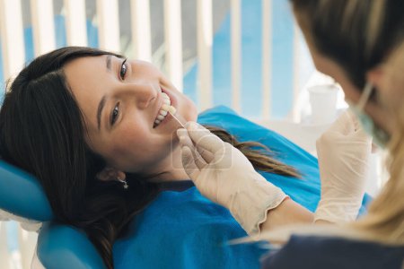 Foto de Primer plano de una paciente en el dentista, ella está comprobando su tono de color de los dientes que se adapte a su mejor. - Imagen libre de derechos