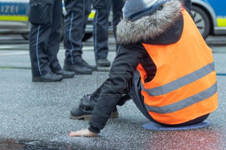 Téléchargez les photos : Une militante pour le climat s'est collée à l'asphalte à Hambourg - en image libre de droit