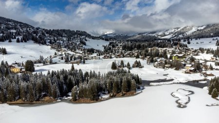Aerial view of wintery Valbella with the frozen Heidsee
