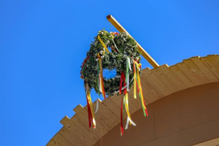 Topping out wreath hangs on an unfinished wooden dormer