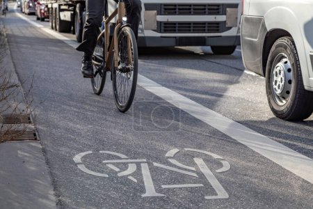 Cyclist rides on bike lane close to truck