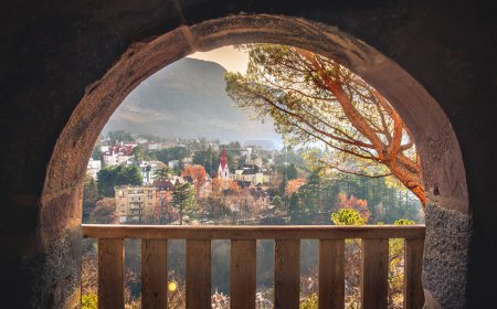 Foto de Ciudad de ensueño paisaje amanecer ciudad en cálidas luces de la mañana de otoño a través de balcón arco de piedra fondo . - Imagen libre de derechos