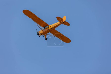 Foto de Avión amarillo. Un solo avión de motor cruza el cielo azul. Transporte.. - Imagen libre de derechos
