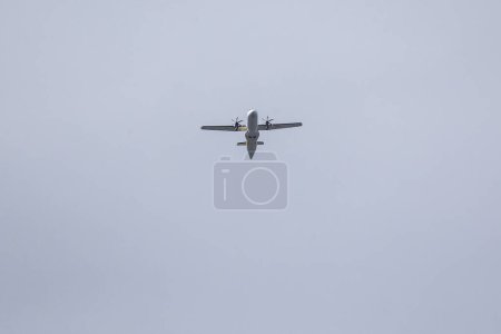Photo for A twin-engine plane flying in a blue sky between clouds. Transportation. - Royalty Free Image