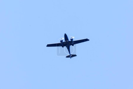 Photo for A twin-engine plane flying in a blue sky. Transportation. Aircraft. Trip. - Royalty Free Image