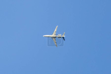 Ein Privatjet fliegt in einem blauen Himmel zwischen Wolken. Transport. Flugreisen. Luxus.