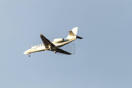 Foto de Un avión jet privado volando en un cielo azul entre las nubes. Transporte. Viaje aéreo. Lujo. - Imagen libre de derechos