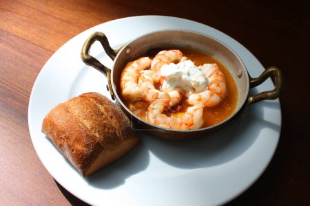 Typical Spanish dish - prawns fried with oil and garlic and small bun