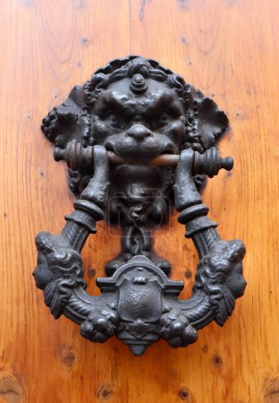Close up view of black door knocker with head in Rome, Italy