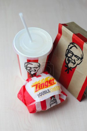 Foto de Bangkok, Thailand - January, 10 2023 : KFC Chicken Burger or Singer Burger served with soft drinks and french fries, KFC is a popular fast food in Thailand. - Imagen libre de derechos