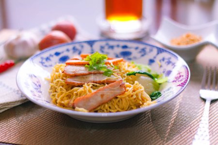 Photo for Egg Noodles with Barbeque Pork in Chinese Style Plates on a Wooden Table with Tea and - Royalty Free Image