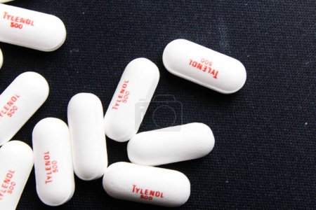 Foto de Bangkok, Tailandia - 10, octubre 2023 - Tylenol píldoras colocadas en el fondo negro, píldoras Tylenol, analgésicos, píldoras para la fiebre, analgésicos en América - Imagen libre de derechos
