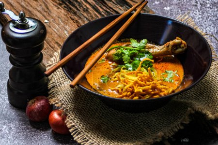 Northern Thai food (Khao Soi Kai), spicy egg noodles soup with chicken in a bowl
