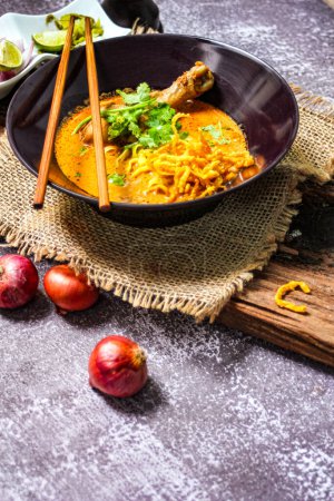 Khao Soi Recipe,Khao Soi,Khao Soi Kai, Thai Noodles Khao Soi, Chicken Curry with seasoning on wooden floor, Northern Thai food concept. (Lanna food)