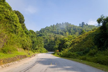 Téléchargez les photos : Cette photo de paysage a été prise, en Asie, au Vietnam, au Tonkin, entre Dien Bien Phu et Lai Chau, en été. On voit une route asphaltée au milieu de la campagne et des montagnes, sous le soleil. - en image libre de droit