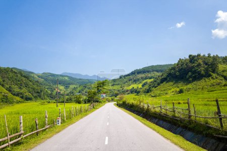 Téléchargez les photos : Cette photo de paysage a été prise, en Asie, au Vietnam, au Tonkin, entre Dien Bien Phu et Lai Chau, en été. On voit une route asphaltée au milieu de la campagne et des montagnes, sous le soleil. - en image libre de droit