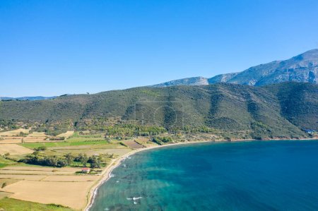 Foto de Esta foto de paisaje fue tomada, en Europa, en Grecia, en Aetolia Acarnania, hacia Patras, junto al mar Jónico, en verano. Vemos la árida costa rocosa y su verde paisaje, bajo el sol. - Imagen libre de derechos