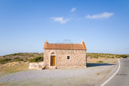 Foto de Esta foto de paisaje fue tomada, en Europa, en Grecia, en Creta, hacia Sitia, en la orilla del mar Mediterráneo, en verano. Vemos una pequeña iglesia cerca del Monasterio de Toplou, bajo el sol. - Imagen libre de derechos