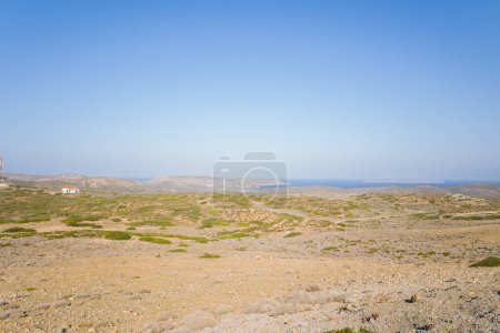 Dieses Landschaftsbild wurde in Europa, in Griechenland, auf Kreta, in Richtung Sitia, am Rande des Mittelmeers, im Sommer aufgenommen. Wir sehen die trockene Landschaft inmitten der Berge, unter der Sonne.