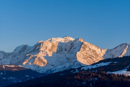 Dieses Landschaftsbild wurde in Europa aufgenommen, in Frankreich, Rhone Alpes, in Savoyen, in den Alpen, im Winter. Wir sehen das Mont-Blanc-Massiv bei Sonnenuntergang unter der Sonne.