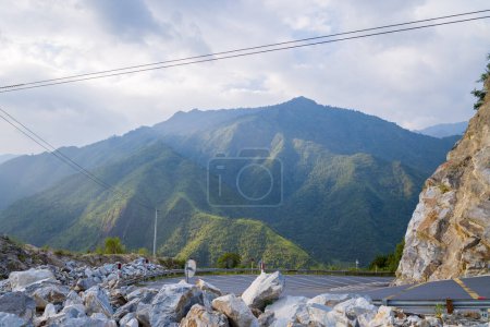 Téléchargez les photos : Cette photo de paysage a été prise, en Asie, au Vietnam, au Tonkin, entre Lai Chau et Sapa, en été. On voit une route asphaltée au milieu de la campagne et des montagnes, sous le soleil. - en image libre de droit