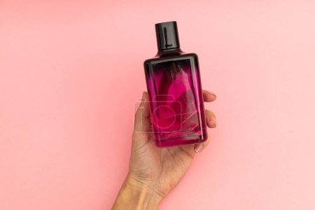 Foto de Perfume en una botella rosa sobre un fondo rosa - Imagen libre de derechos