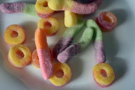 Photo for Sweets of children's candies in the form of sweet earthworms of different colors, American donuts, lollipops. - Royalty Free Image