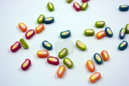 Photo for Interesting and unusual, colored caramel candies, sweets with a white center are located on a white matte background. - Royalty Free Image