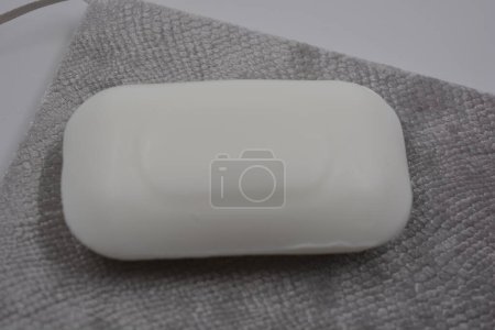Téléchargez les photos : Magnifique, élégant, barre blanche de savon sans logo et nom placé sur un fond gris, velours écailleux. - en image libre de droit